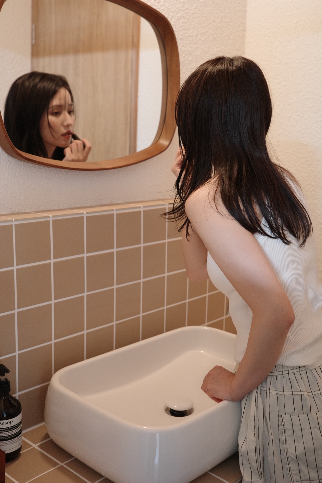 uonの洗面スペースで身支度をする女性